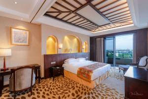 una camera con letto e scrivania e una camera con finestra di Grand Metropark Longxi Conference Center Beijing a Pechino