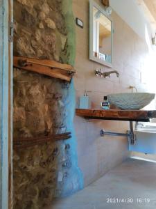 a bathroom with a sink and a stone wall at IL PIACERE DELLA NATURA in Cansano