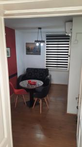 a living room with a table and a couch at Apartmani LolaNola in Vrnjačka Banja