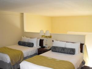 a hotel room with two beds and two lamps at Plantation on Crystal River, Ascend Hotel Collection in Crystal River