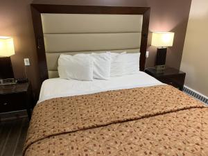 a bedroom with a large bed with two night stands at Rogers Motel in Smiths Falls