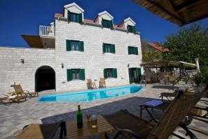 a building with a swimming pool in front of it at Villa Monica in Ložišće