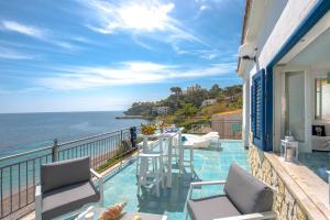 a balcony with a table and chairs and the ocean at Dimore di mare by Lisca Bianca Rental in Santa Flavia