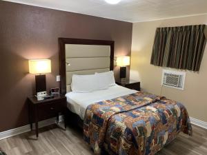 um quarto de hotel com uma cama e duas lâmpadas em Rogers Motel em Smiths Falls