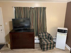 a living room with a tv and a chair at Rogers Motel in Smiths Falls
