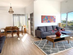 uma sala de estar com um sofá e uma mesa em Minto Merimbula em Merimbula
