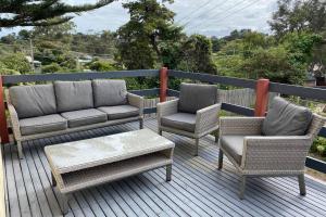 a deck with chairs and a couch and a coffee table at The Tea Trees Retreat in Rye in Rye