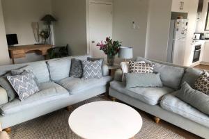 a living room with a couch and a table at The Tea Trees Retreat in Rye in Rye