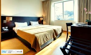 ein Hotelzimmer mit einem Bett und einem Fenster in der Unterkunft Hotel Conde de Agueda in Águeda