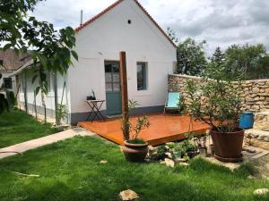 una casa con terraza de madera en el patio en Káli Kerted Vendégházak Monoszló Mariska néni háza en Monoszló