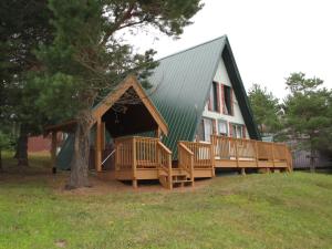 ein großes Grün- und Holzhaus mit einer Veranda in der Unterkunft Mittenwald in Bessemer