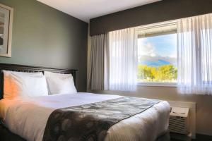 a bedroom with a large bed and a window at Prestige Hudson Bay Lodge & Conference Centre, WorldHotels Crafted Collection in Smithers