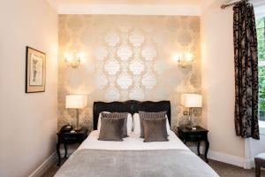 Un dormitorio con una cama grande con dos mesitas de noche. en Southcrest Manor Hotel, Best Western Signature Collection, en Redditch