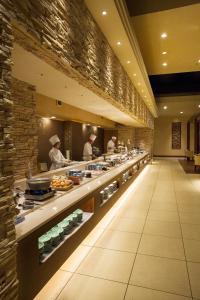 a buffet line in a restaurant with chefs preparing food at Kusatsu Now Resort Hotel in Kusatsu