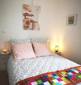 a bedroom with a bed with a colorful quilt on it at NICE APPARTEMENT in Amboise