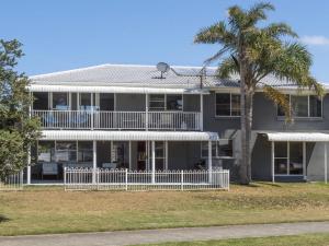 una casa con una palmera delante en Kendalls One, en Kiama