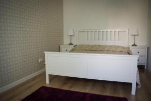 a bedroom with a white bed with two night stands at Šaulys in Druskininkai