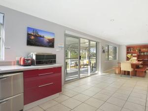 a kitchen with a microwave and a dining room at Kendalls Two in Kiama