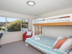 1 dormitorio con litera y silla roja en Kendalls Two, en Kiama