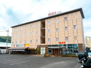 a large building with a parking lot in front of it at Kumamoto Ichibamae Business Kurenai Hotel in Kumamoto