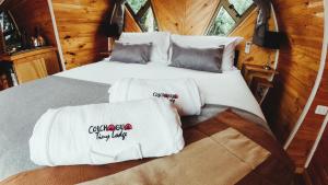 a bed in a tiny house with towels on it at Colchagua Tiny Lodge in Santa Cruz