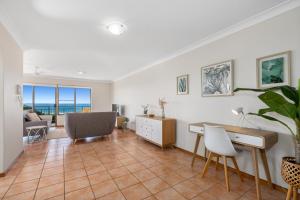 a living room with a desk and a table at Sea Gaze Apartments by Kingscliff Accommodation in Kingscliff