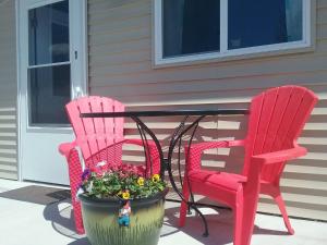 two red chairs and a table with a flower pot at Beach Mirage Suites in Brook Park