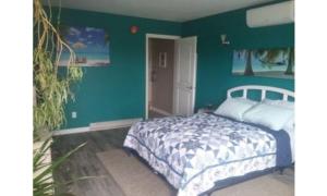 a bedroom with a bed and a green wall at Beach Mirage Suites in Brook Park