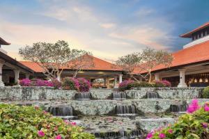 a garden with flowers in front of a building at Grand Hyatt Bali in Nusa Dua