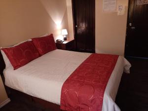 a bedroom with a large bed with red pillows at Hotel Bonaventure in Quito