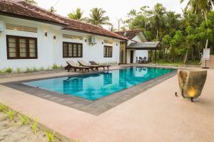 a swimming pool in front of a house at Sathmin Villa in Ahangama