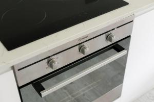 a stove top oven with a drawer in a kitchen at GuestReady - West Kensington Home wBalcony in London