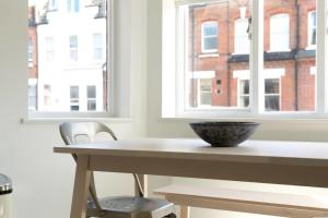 a table with a bowl on it next to a window at GuestReady - West Kensington Home wBalcony in London