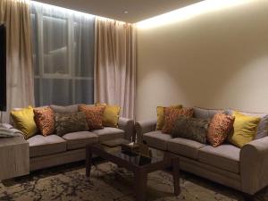 a living room with two couches and a table at Lavender Hotel in Taif