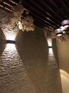 een rij lichten hangend aan een stenen muur bij Lavender Hotel in Taif