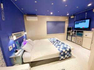 a bedroom with a bed and a flat screen tv at feel in Tamatsu