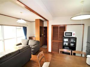 uma sala de estar com um sofá e uma mesa em Maison Ota Building A Building B - Vacation STAY 11138 em Takamatsu