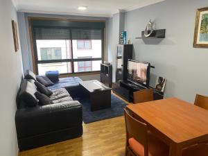 uma sala de estar com um sofá e uma mesa em Piso céntrico, con amplia terraza, 3 dormitorios em Ribeira