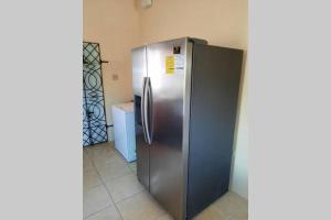 un grande frigorifero in acciaio inossidabile in una stanza di Rick's Reggae Villa a Montego Bay