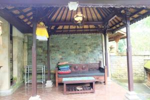 pawilon z ławką i stołem na patio w obiekcie Rumah Kelinci w mieście Ubud