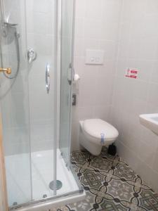 y baño con ducha, aseo y lavamanos. en Riparo di Masseria Urbana en Crispiano