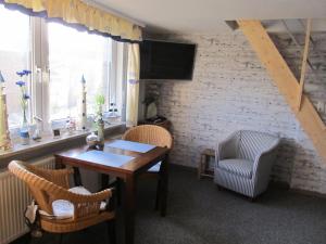 - un salon avec une table, des chaises et une télévision dans l'établissement Landhaus beim See, à Großheide