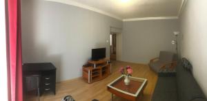 a living room with a couch and a tv at Apartman BEA, SNP 12 Veľký Krtíš in Veľký Krtíš