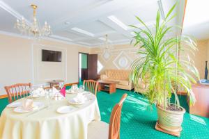 a dining room with a table and a plant at Polaris in Surgut