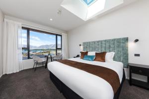 a bedroom with a large bed and a large window at Galaxy Boutique Hotel in Lake Tekapo