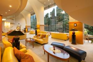 a lobby with yellow furniture and yellow chairs at Arima Onsen Gekkoen Korokan in Kobe