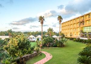 um resort com palmeiras e um grande edifício em Blue Hawaii Hotel em Jeju