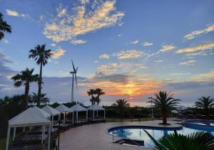 a resort pool with a windmill in the background at Blue Hawaii Hotel in Jeju