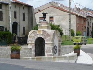 a building with a fountain in the middle of a street at Charmant Gîte en Lorraine, Proche Nancy et Vosges, Terrasse et Confort Tout Équipé - FR-1-584-59 in Rozelieures
