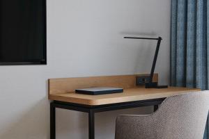 a desk with a lamp on it with a chair at Hotel Hyundai by Lahan Ulsan in Ulsan